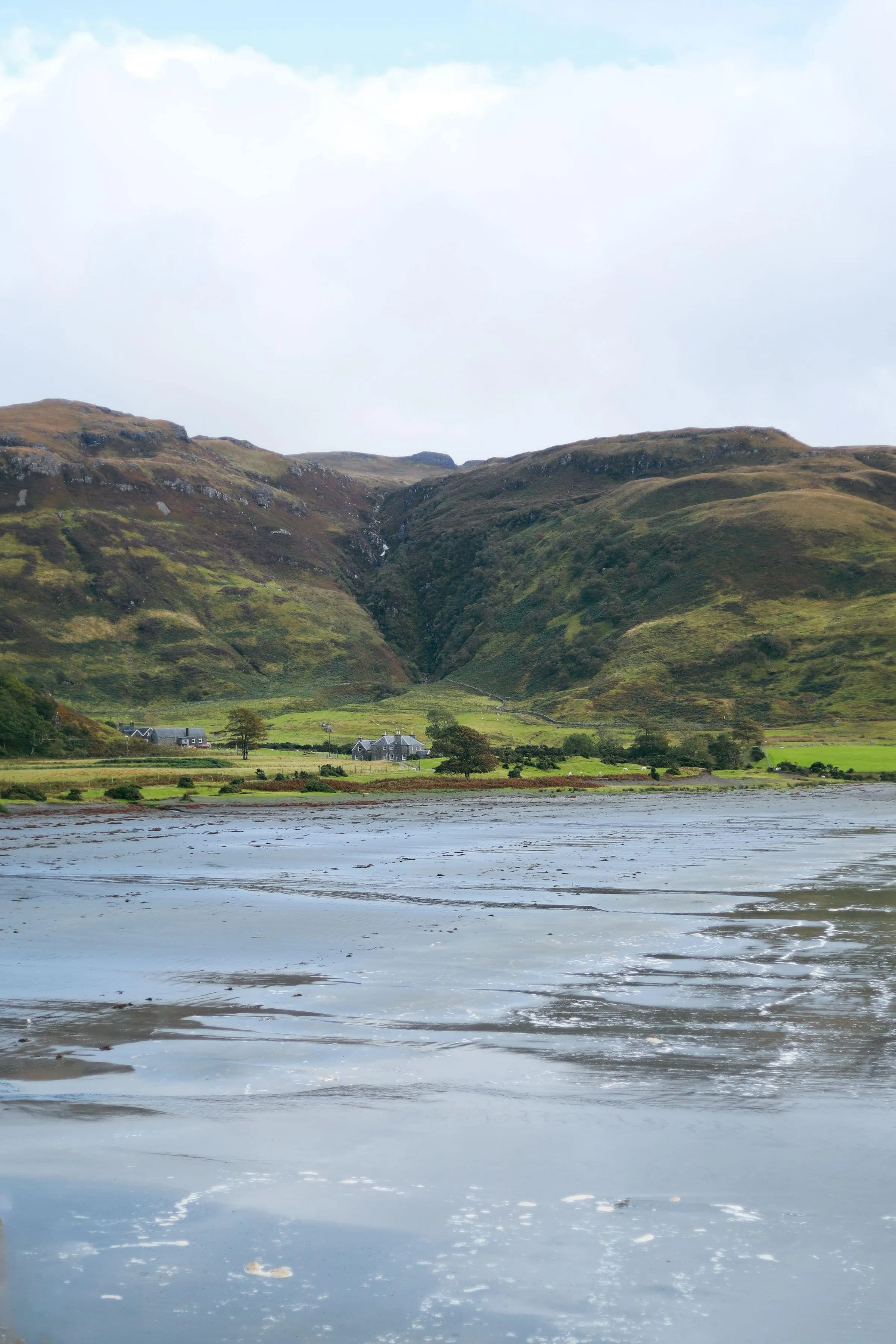 A still Highland loch below bare hills under grey cloud