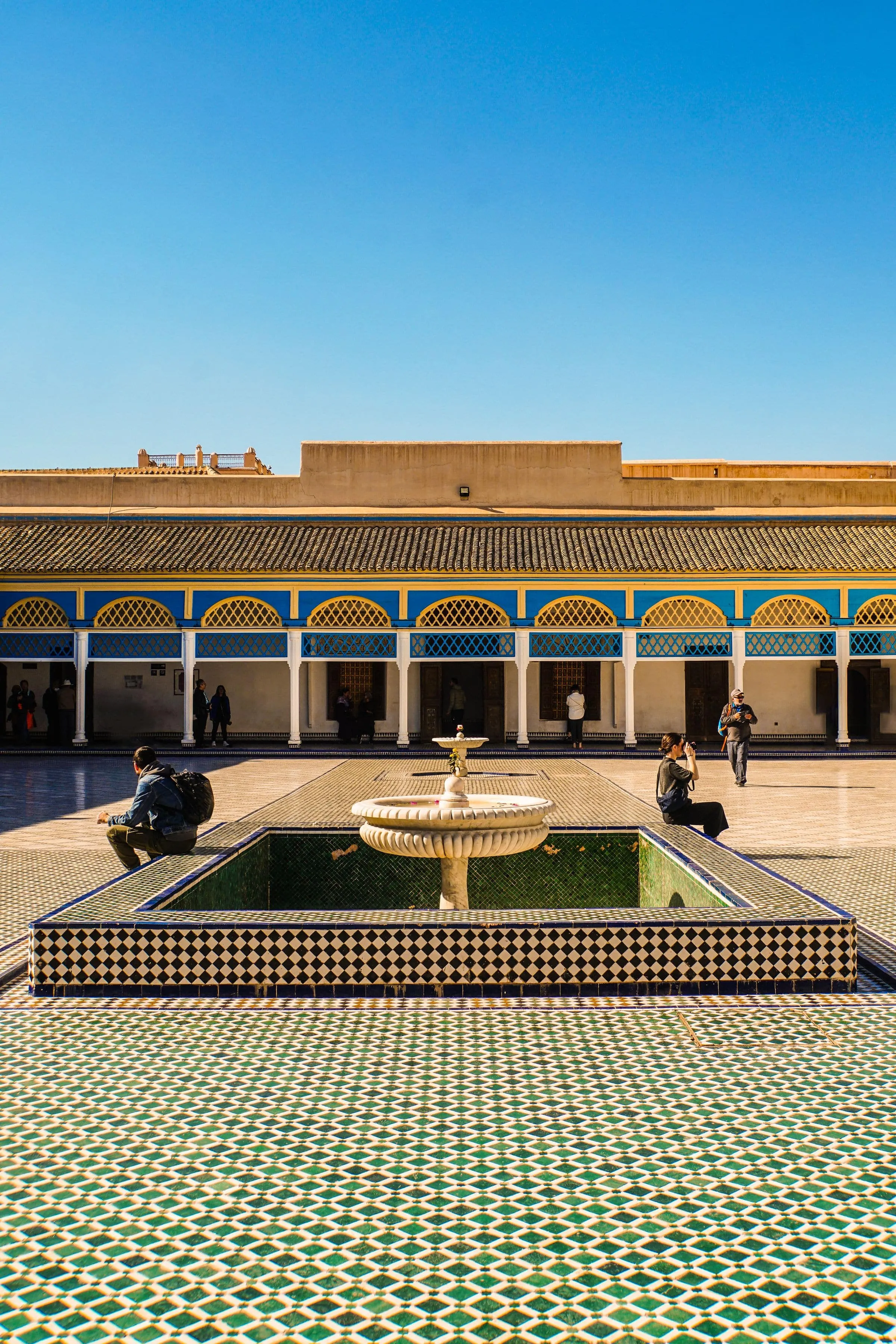 A tiled courtyard with a central fountain and horseshoe arches
