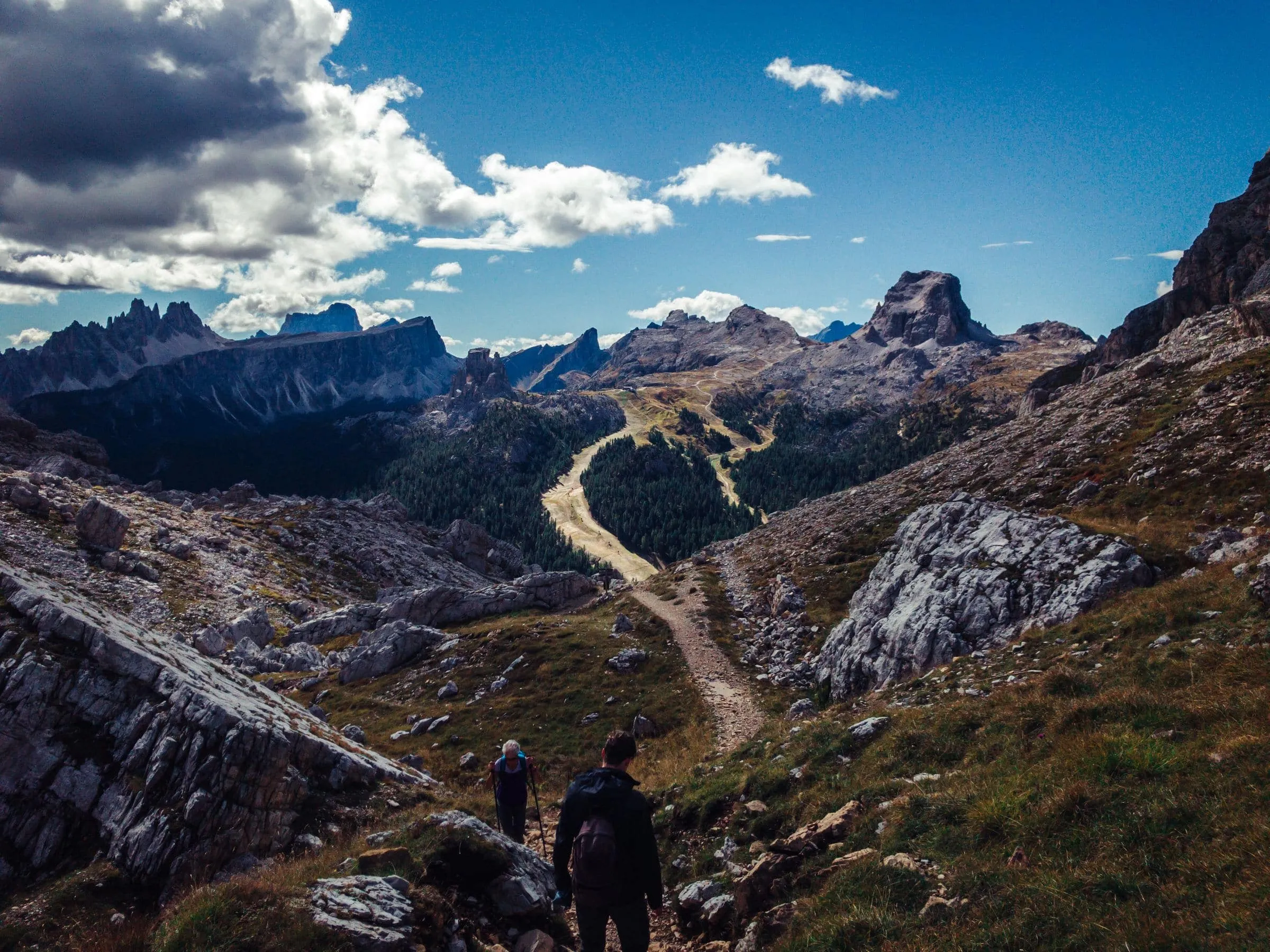 A stone path traversing high above a green mountain valley