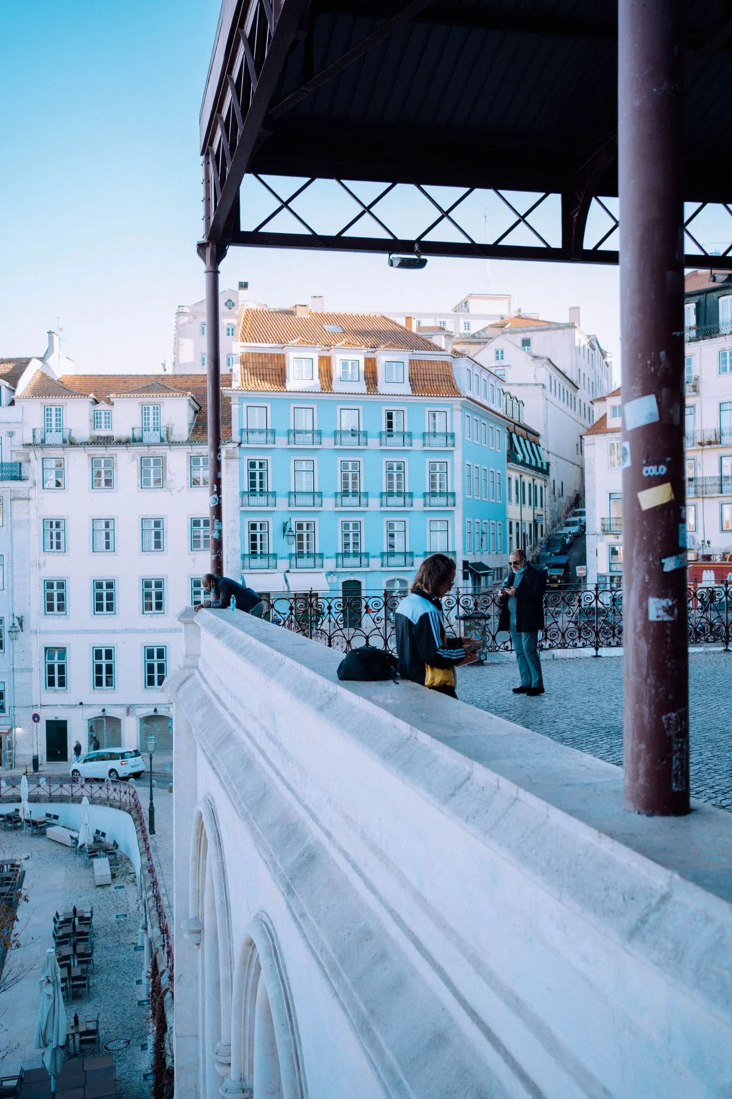Pale blue and white Lisbon apartment buildings above a cobbled square