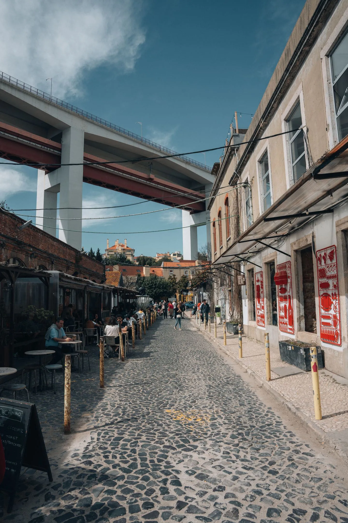 A Lisbon street framed by a stone arch with the river beyond