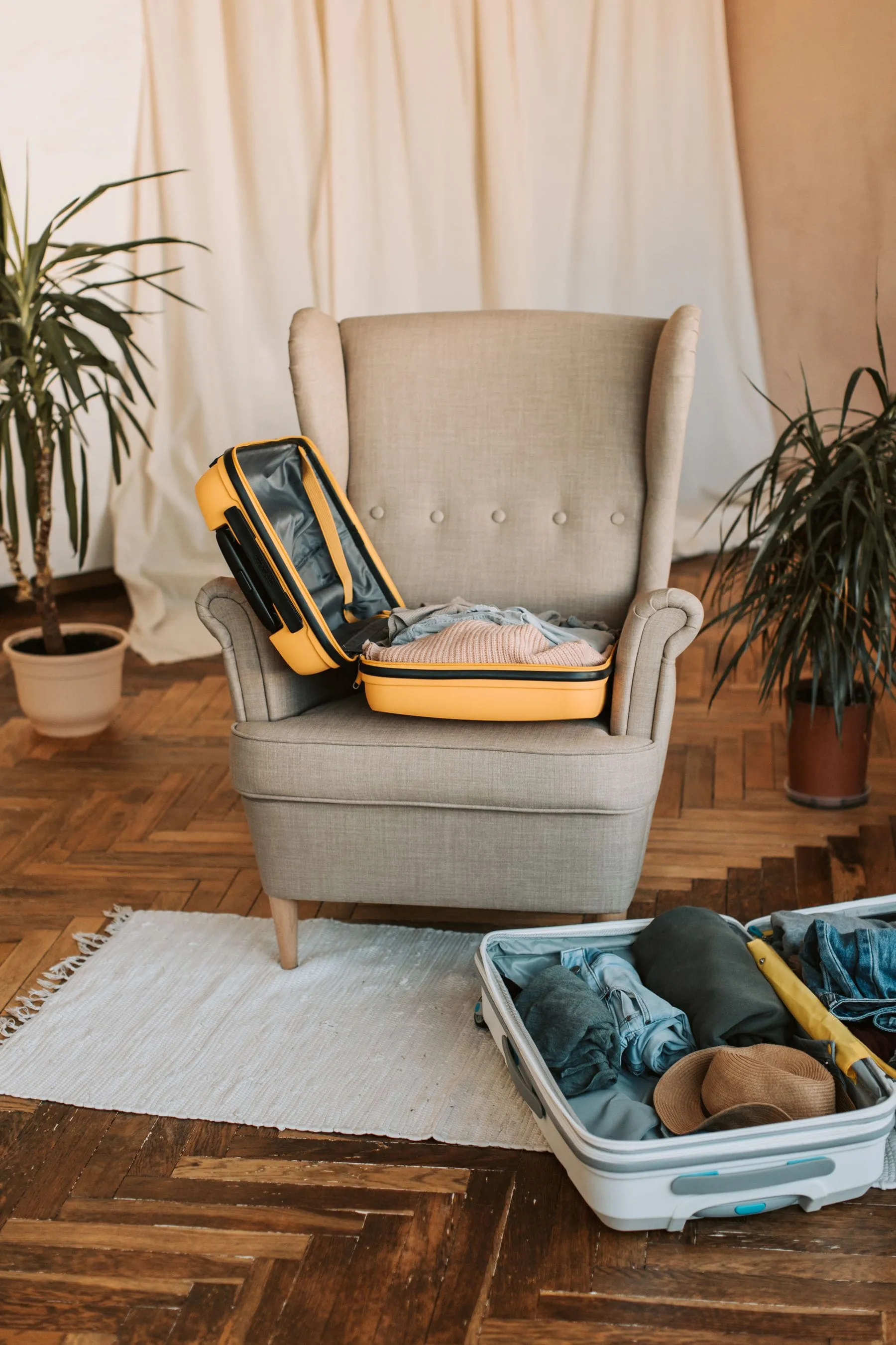 Hands folding clothes into a packing cube inside a suitcase