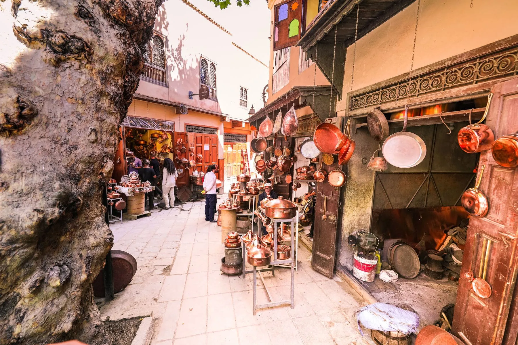 A shopfront hung with lamps and mirrors in a covered market lane
