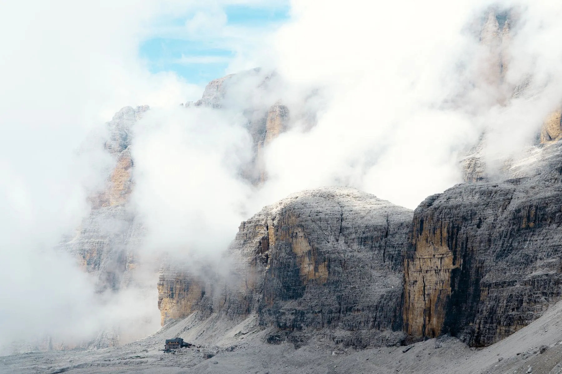 Grey limestone towers rising out of low cloud