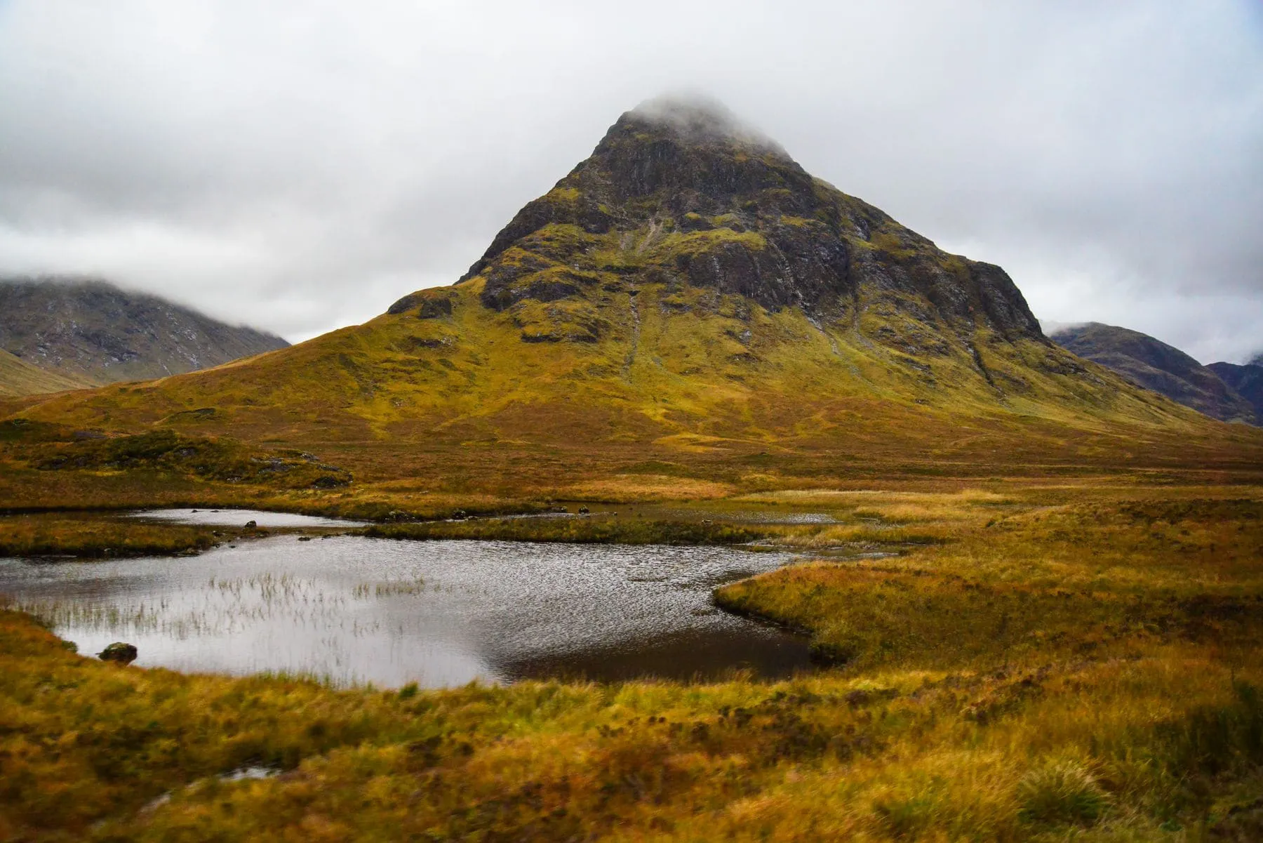 A dark peak rising over a flat sheet of water